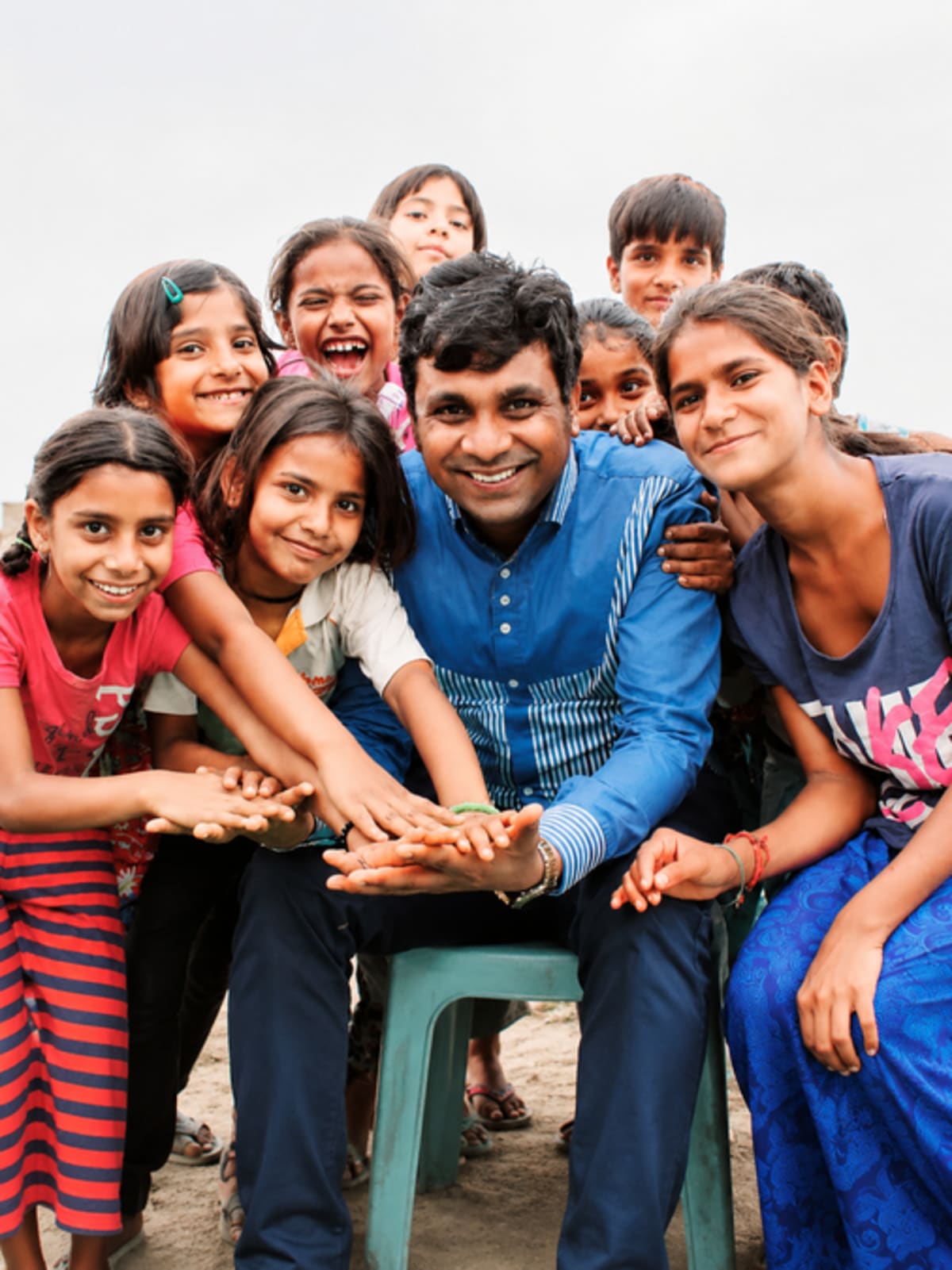 Devendra Kumar smiling with young girls in school uniforms at Ladli Foundation program