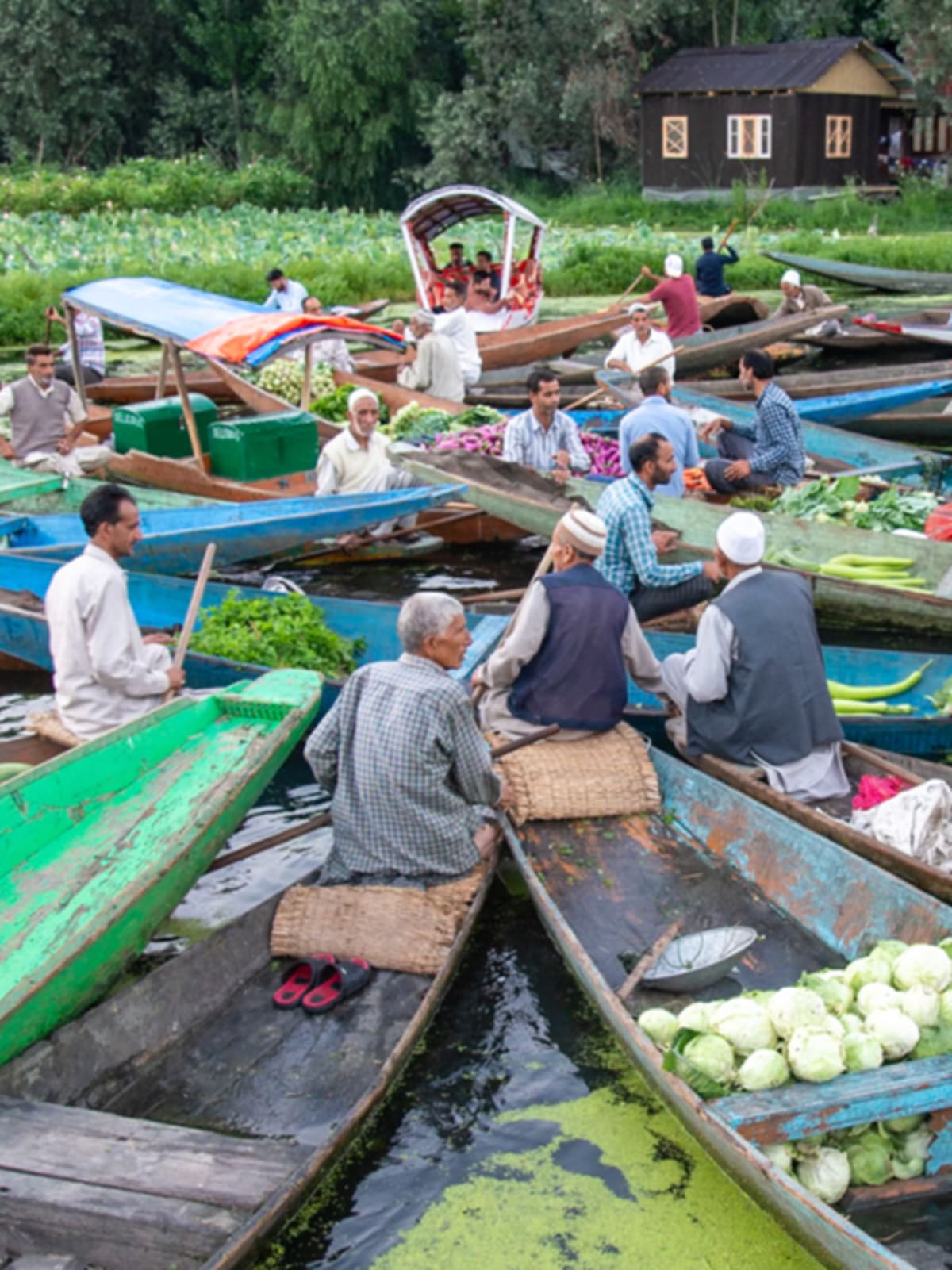 Wooden shikaras filled with vegetables gather at sunrise on Kashmir's Dal Lake floating market