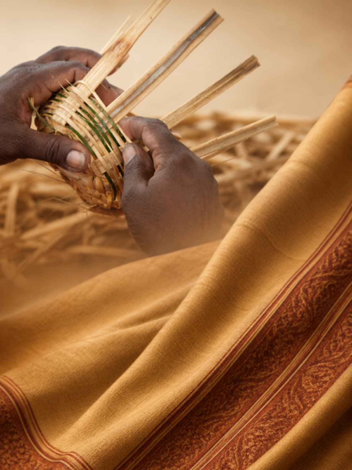 Traditional handwoven silk fabric with golden sheen displayed alongside tribal silver jewelry pieces