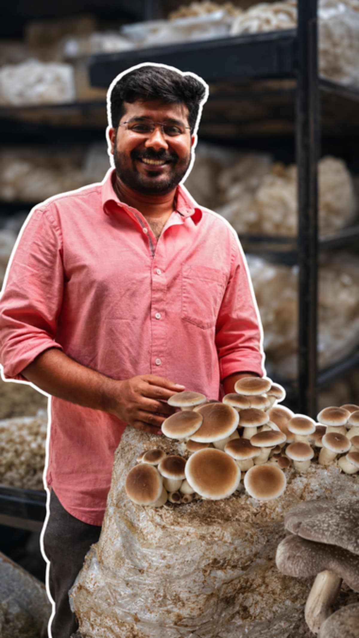Young farmer Jithu Thomas holding freshly harvested oyster mushrooms in Kerala growing facility