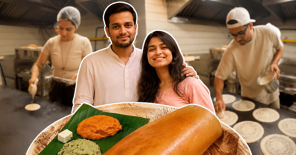 Couple standing in their small Mumbai cafe serving traditional South Indian dosas to customers