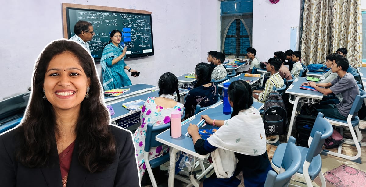 Indian primary school students sitting at new wooden bench-desks in bright classroom