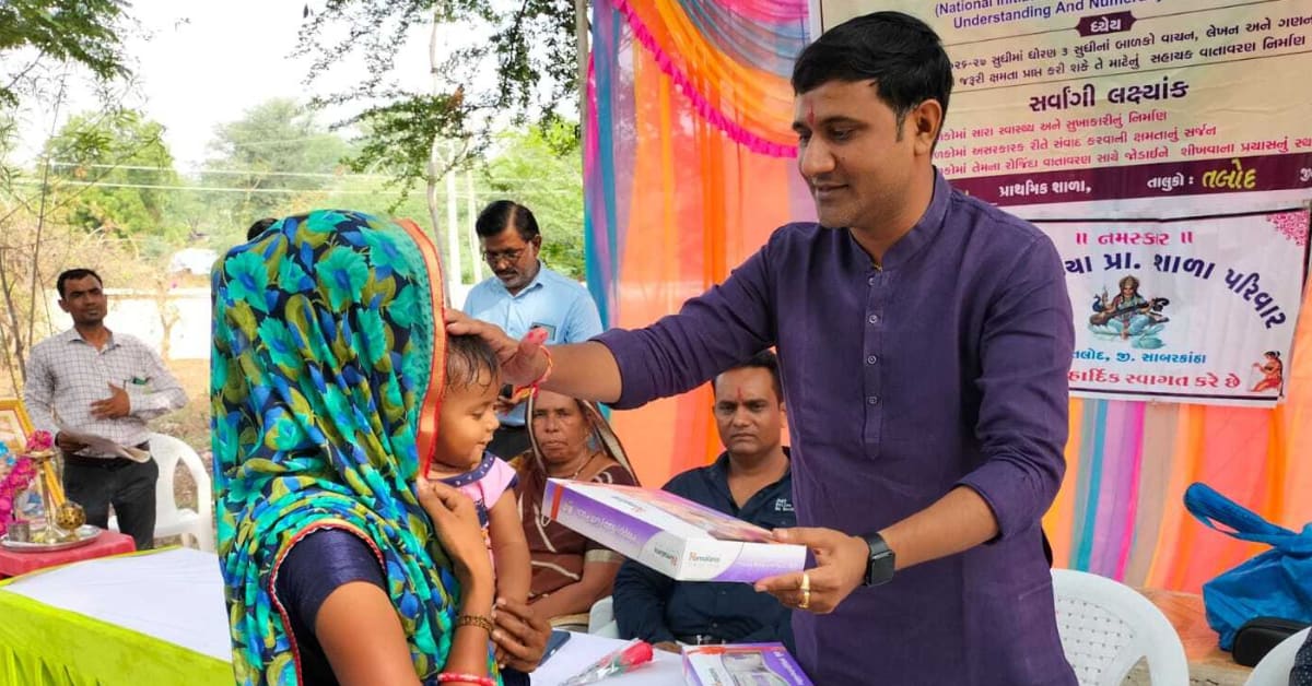 Dr. Ebha Patel smiling at a village celebration ceremony honoring a newborn baby girl