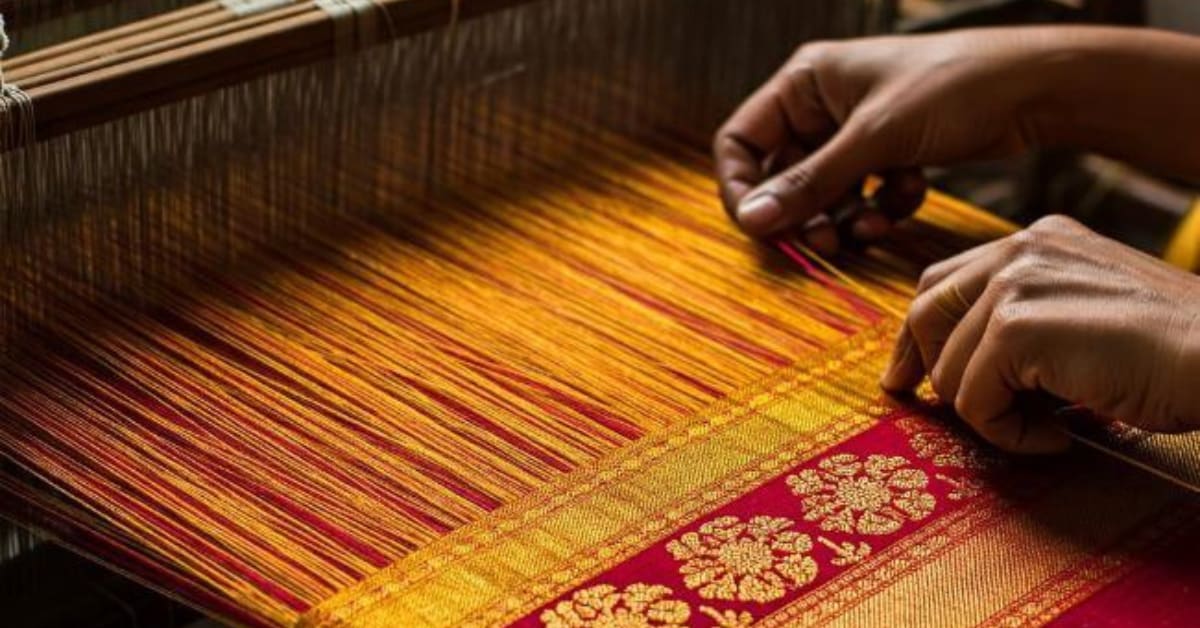 Woman in Madanpura carefully trimming threads from underside of silk Banarasi saree