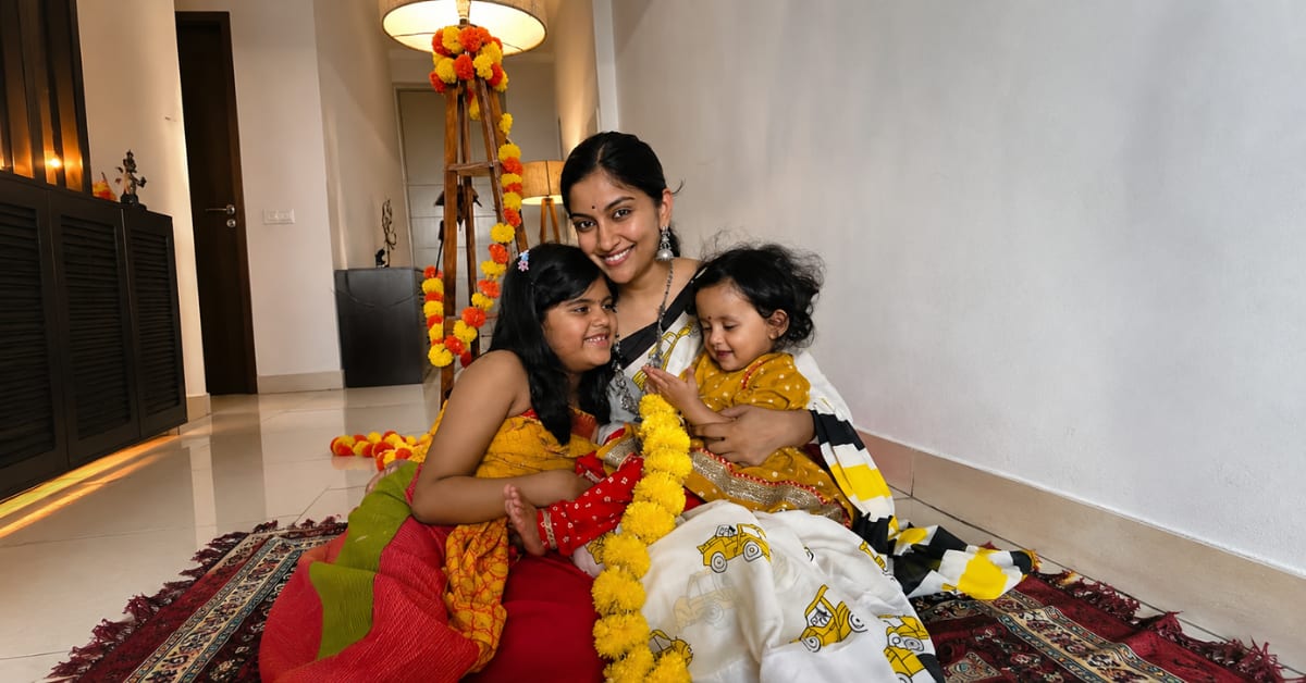 ** Dr. Madhavi Bharadwaj, pediatrician and parenting educator, smiling with her two young daughters