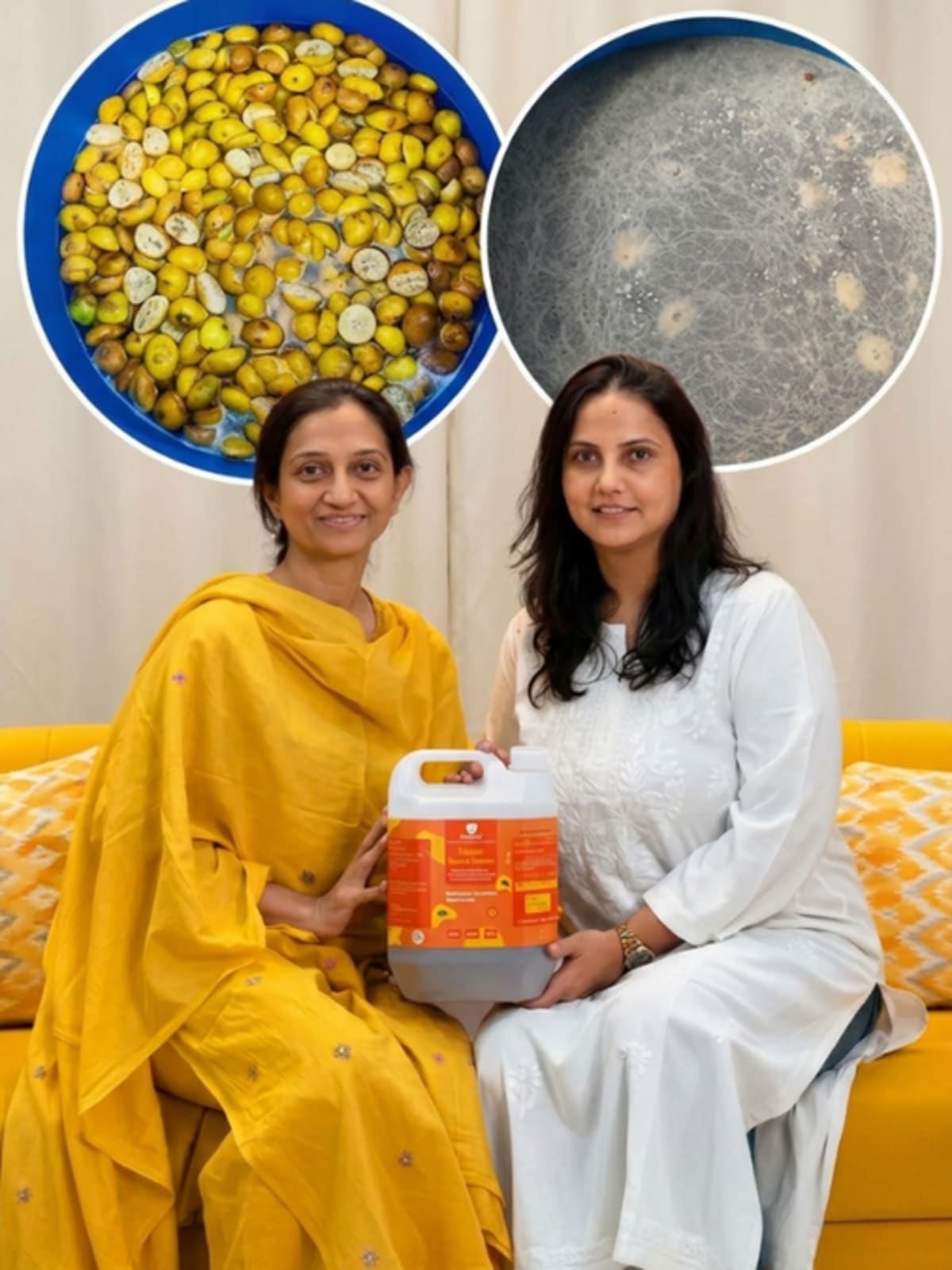 Two women standing beside large fermentation drums filled with citrus peels on a Mumbai terrace