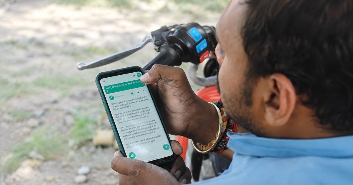 Indian farmer using smartphone to photograph crop disease for AI diagnosis app FarmerChat