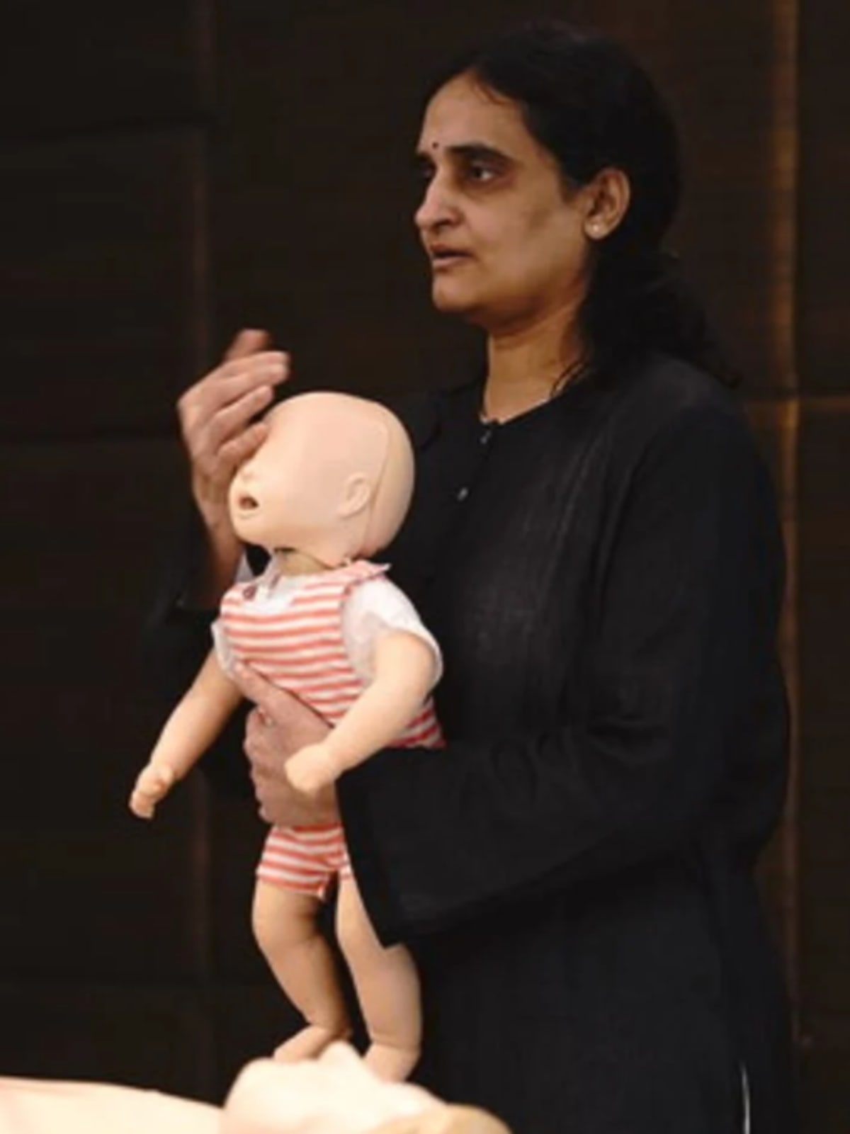 Dr. Sivaranjani demonstrating CPR technique on training mannequin during community workshop