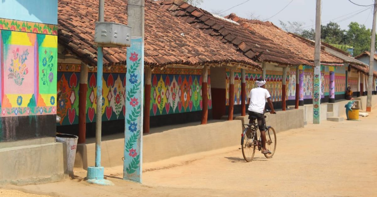 Decorated traditional thatched-roof homes with colorful wall art in Babojola village, Odisha, India