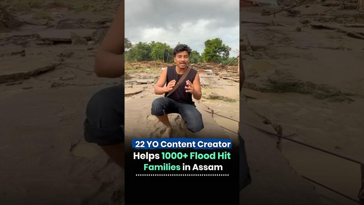 Relief worker carrying supplies through deep floodwater in rural Assam village