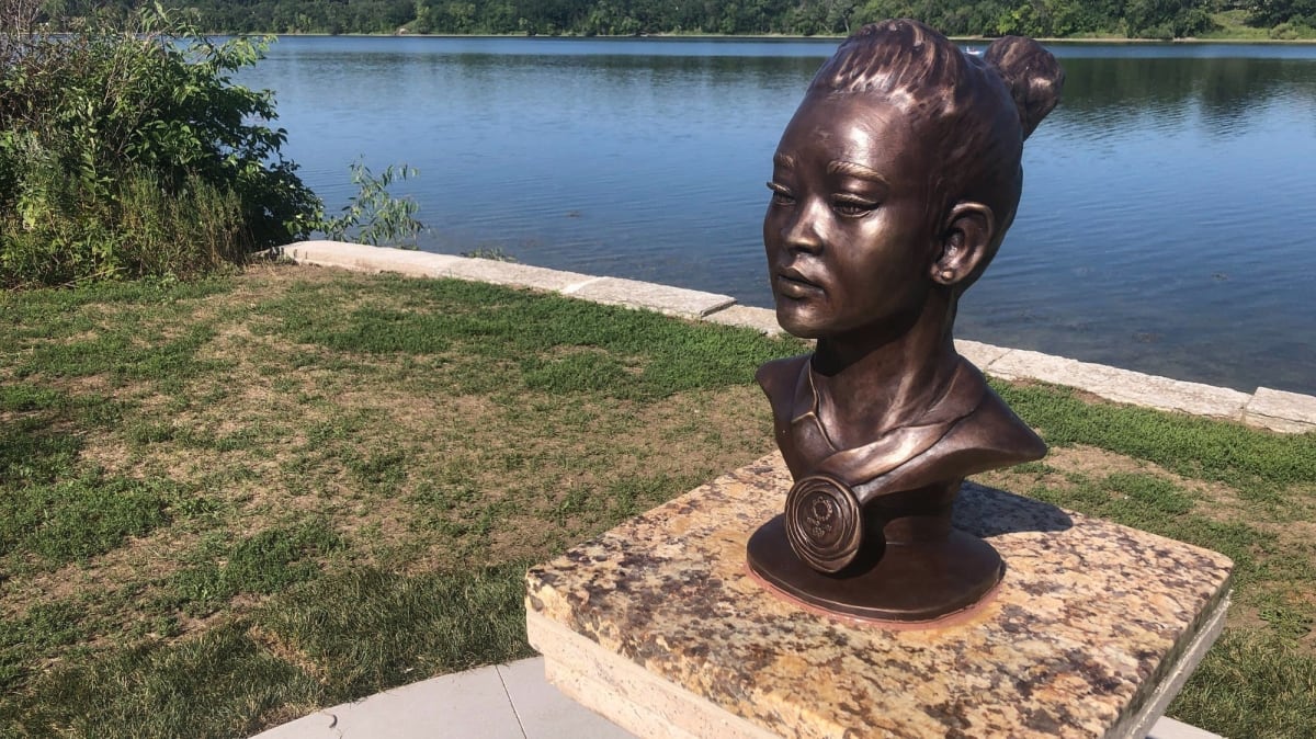 St. Paul police officers gathered around recovered bronze sculpture of gymnast Suni Lee