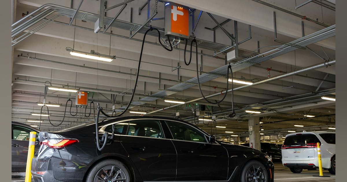 Overhead electric vehicle charging stations with retractable cables at Portland International Airport rental facility