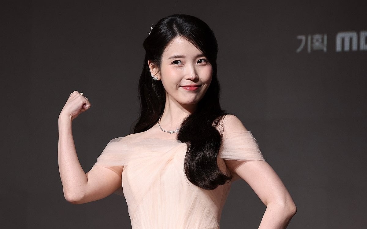 Korean singer-actress IU smiling, known for regular charitable donations to communities in need