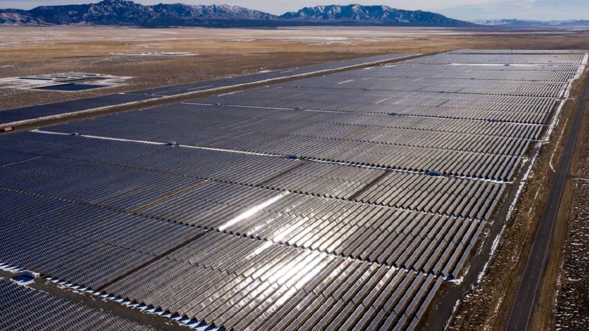Solar panels and wind turbines generating renewable energy under clear Utah skies