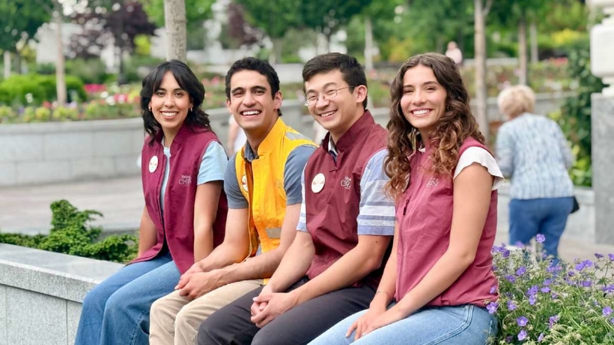 Volunteers wearing name tags smile while preparing for Salt Lake Temple Celebration events