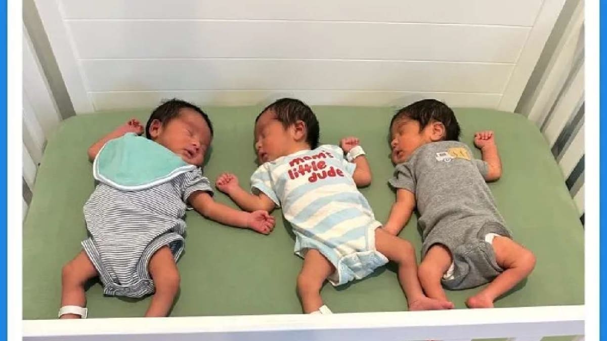 Three newborn baby boys lying together after rare natural triplet birth in Los Angeles