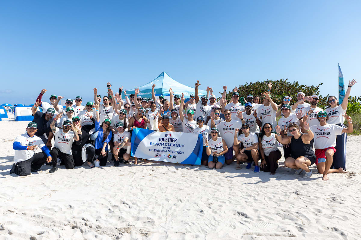 Former MLB players and volunteers gather with cleanup supplies at Miami Beach before environmental cleanup event