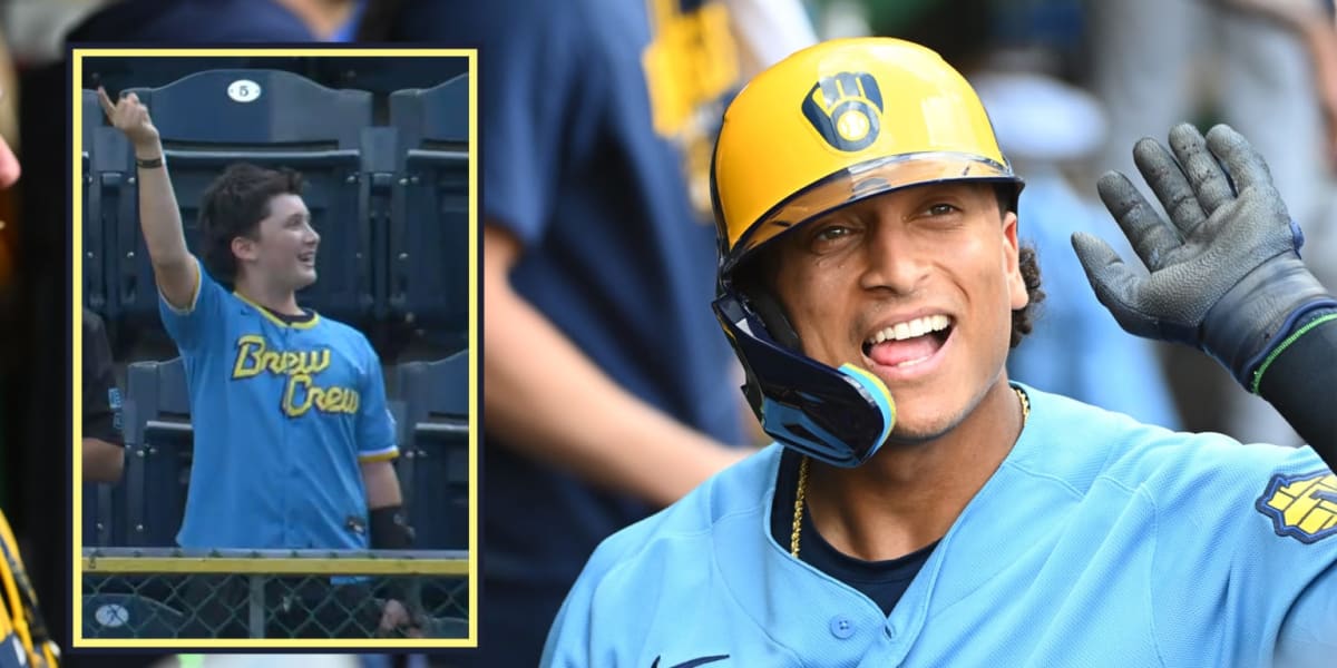 Young Brewers fan in stands reaching with baseball cap to catch home run ball