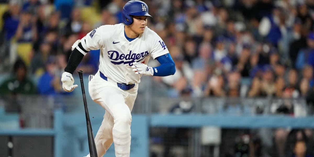 Shohei Ohtani in Dodgers uniform celebrating after reaching base during historic streak
