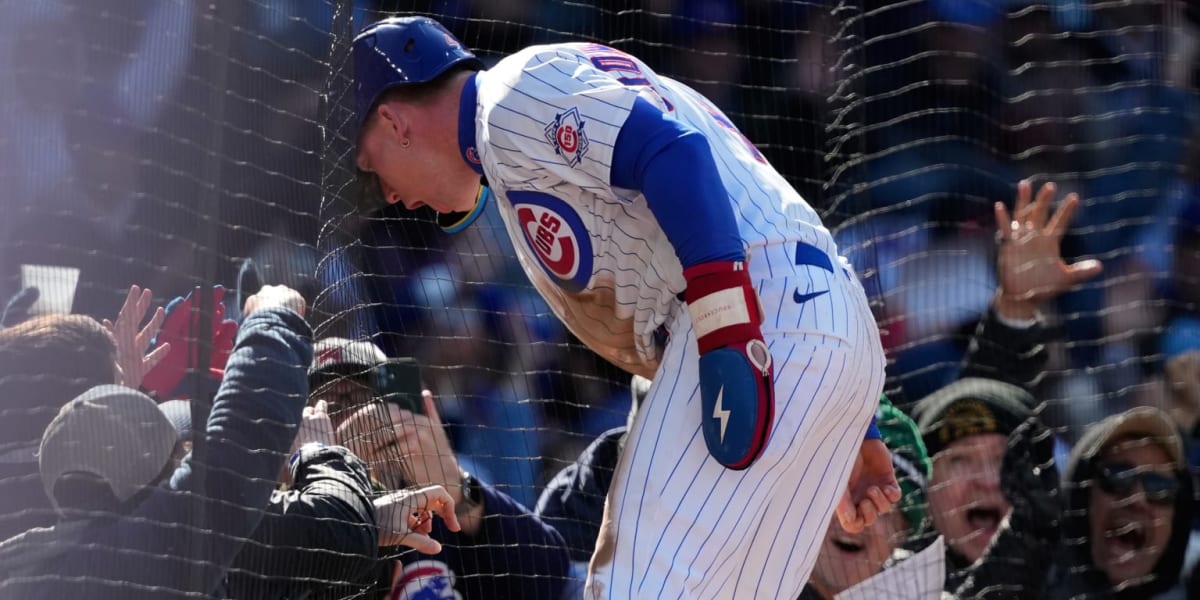 Pete Crow-Armstrong celebrating with Cubs fans on brick wall at Wrigley Field after scoring winning run