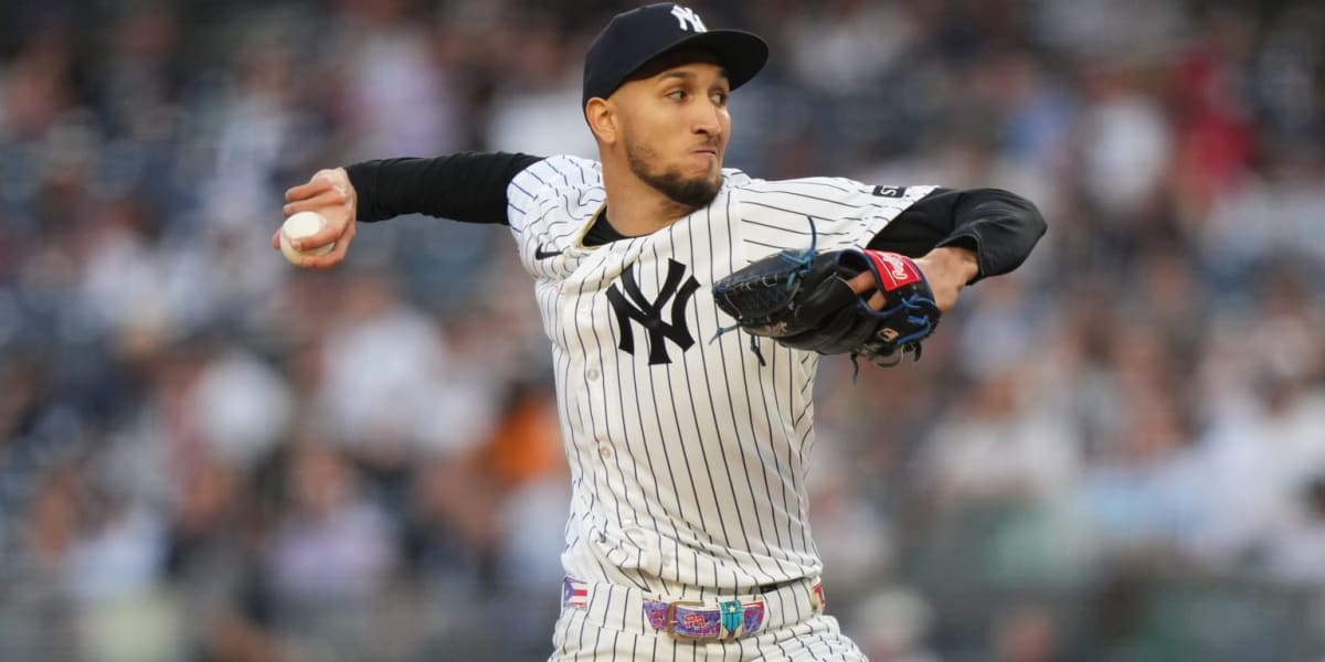 ** Young Yankees pitcher Elmer Rodríguez in pinstripe uniform preparing to throw pitch