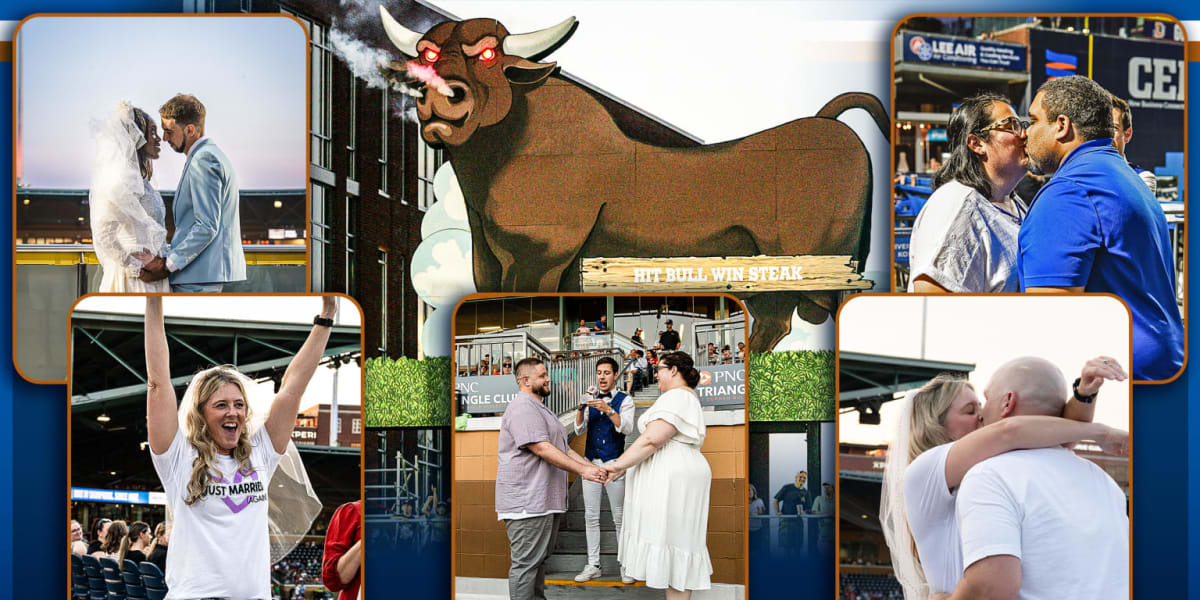 Couple exchanging wedding vows on Durham Bulls baseball field surrounded by cheering crowd