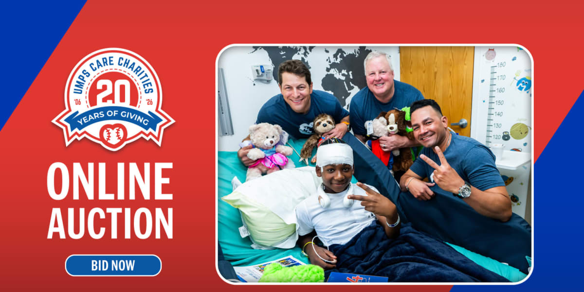 Baseball umpire interacting with young children at community charity event hosted by UMPS CARE