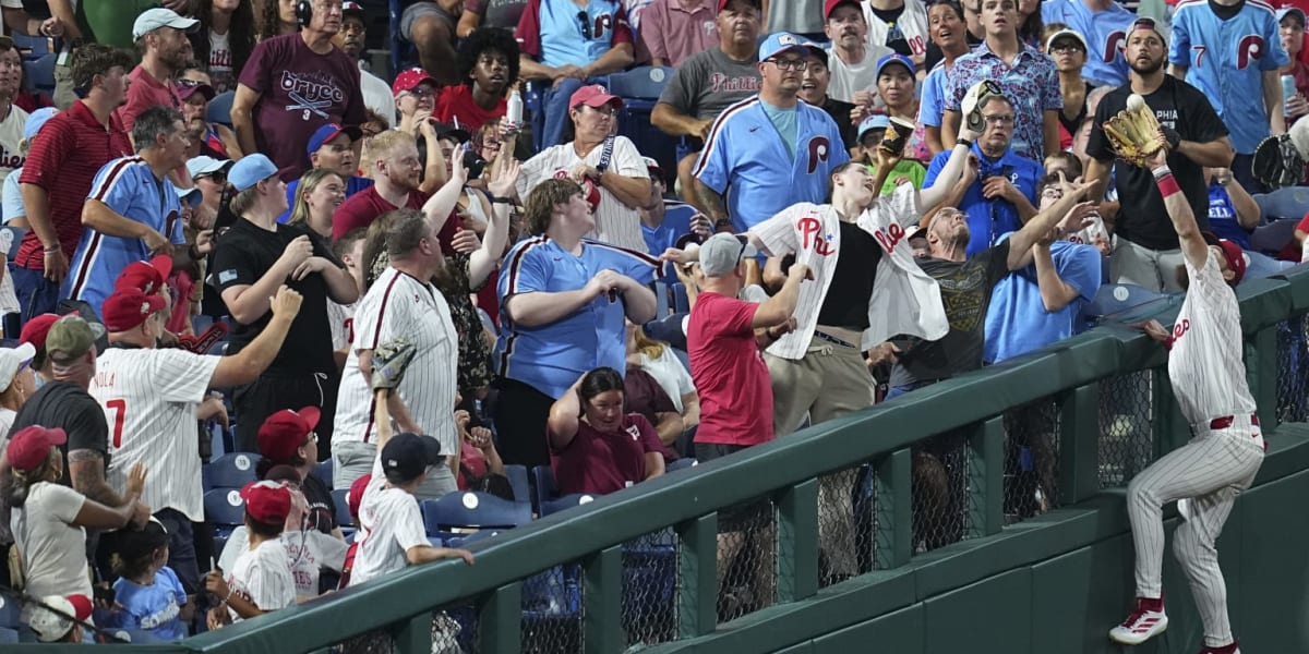 Philadelphia Phillies left fielder Brandon Marsh climbing outfield wall to make spectacular catch