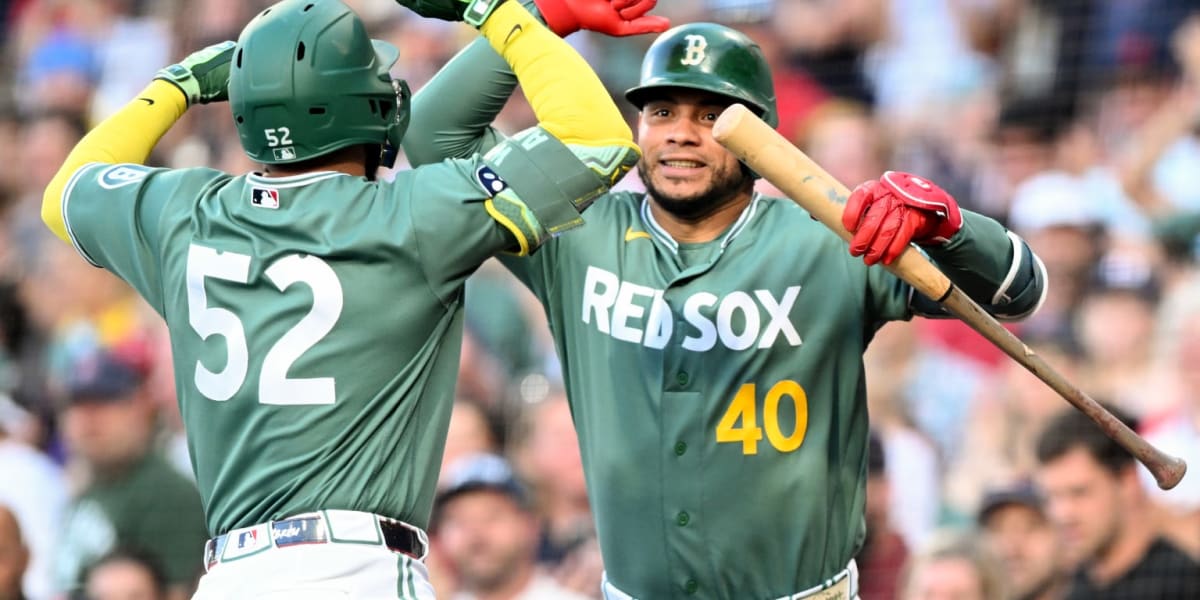 Boston Red Sox players celebrating together on the field at Fenway Park during their winning streak