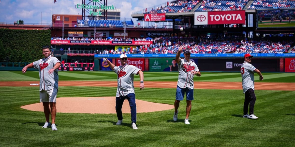 Four former Philadelphia Phillies players in uniforms throwing ceremonial first pitches at Citizens Bank Park