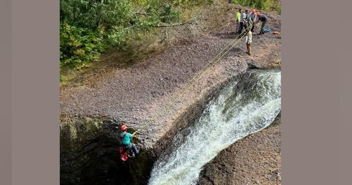 Rescue team members hoisting survivors to safety near Rainbow Falls Michigan waterfall