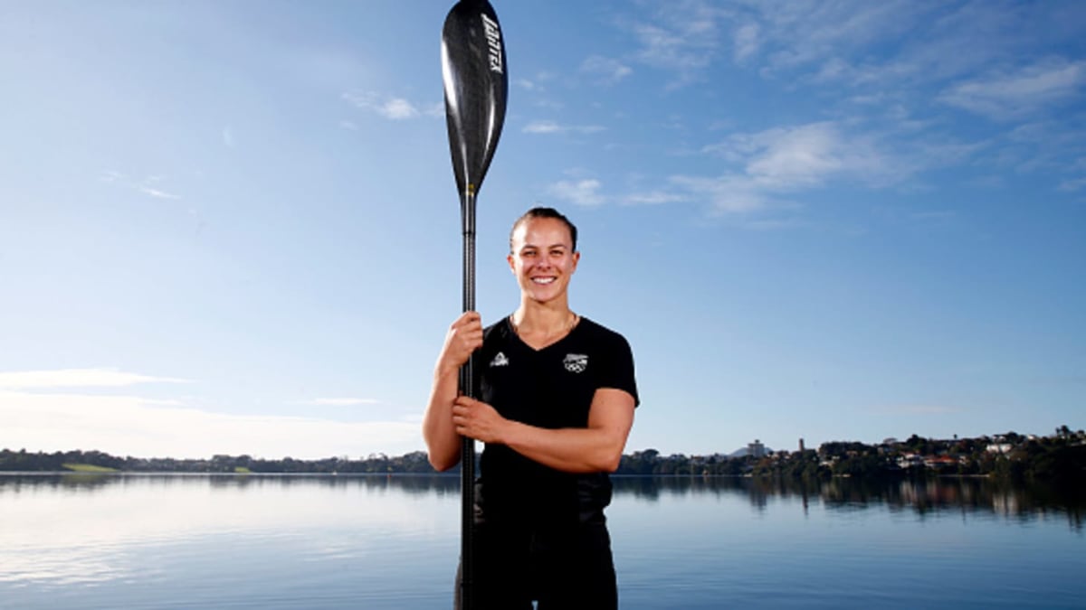 Lisa Carrington paddling her kayak during Olympic competition wearing New Zealand team uniform
