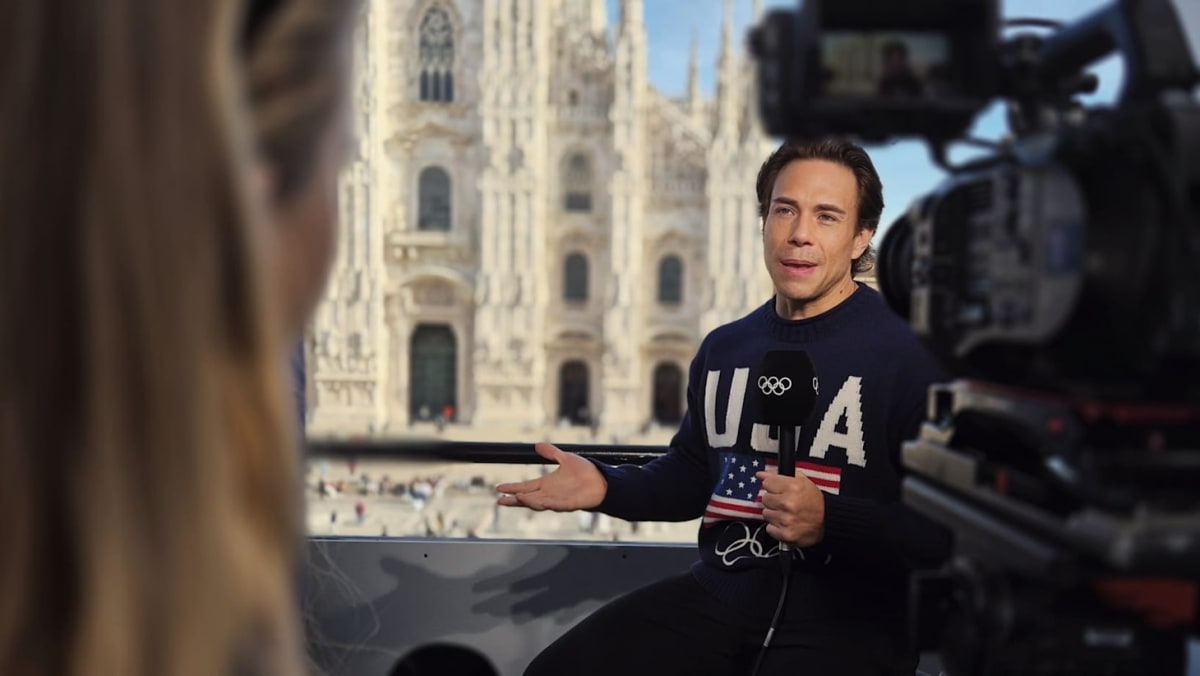 Olympic speed skater Apolo Ohno wearing Team USA uniform smiling at camera
