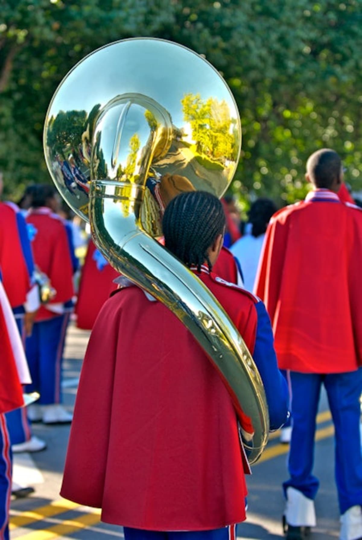 ** HBCU marching band students in colorful uniforms performing energetically on football field