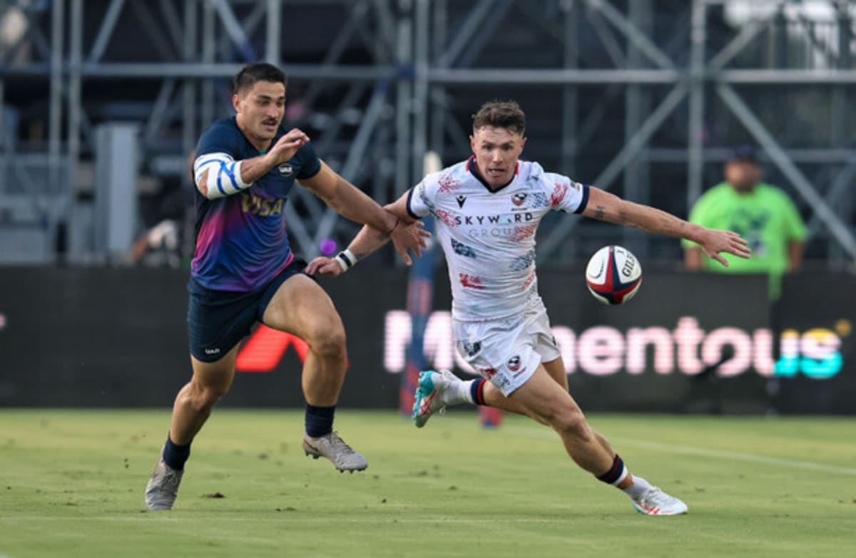 Rugby player Mark O'Keeffe in USA Eagles jersey running with ball during international match