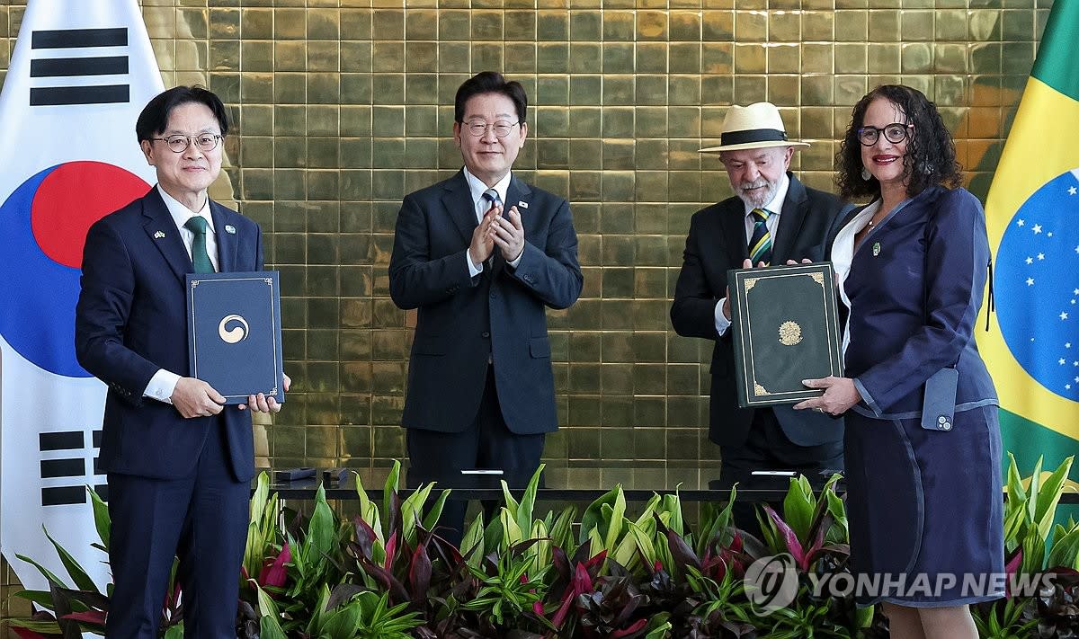 South Korean and Brazilian ministers shake hands at signing ceremony with both presidents standing behind them