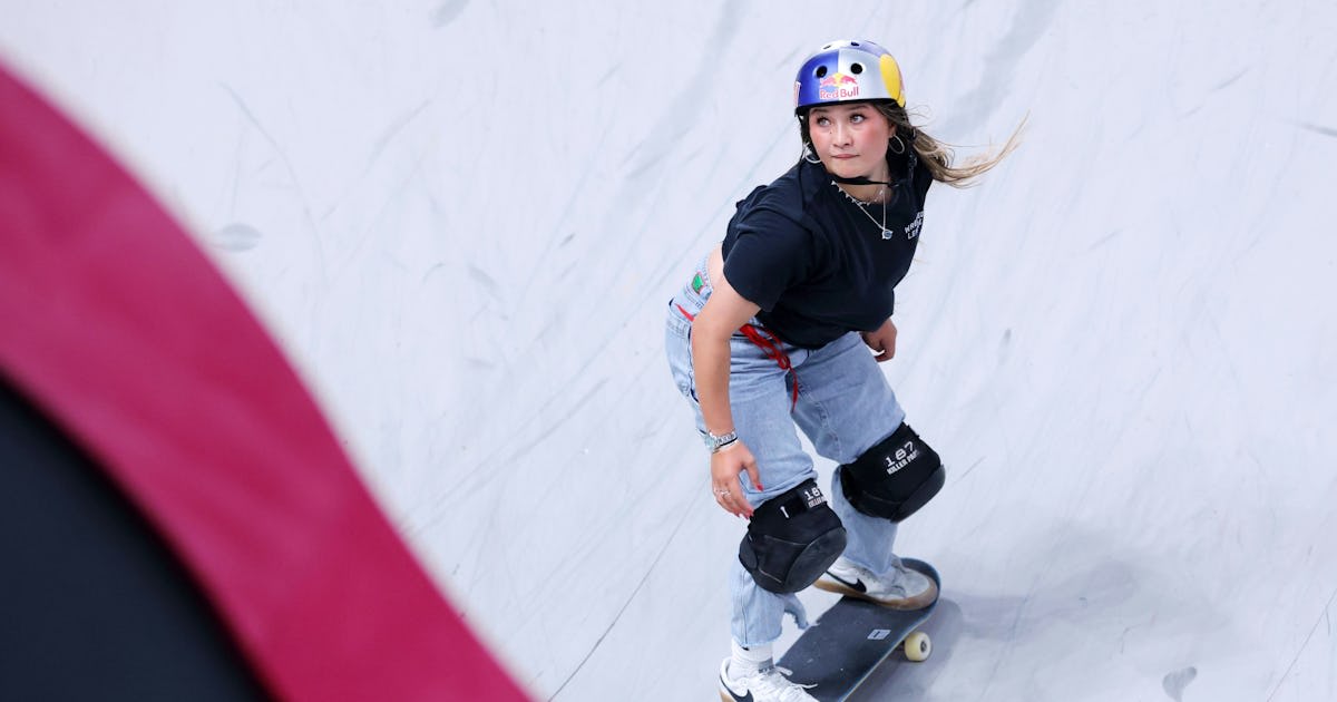 ** Teen skateboarder Sky Brown wearing helmet and knee pads performing trick at competition