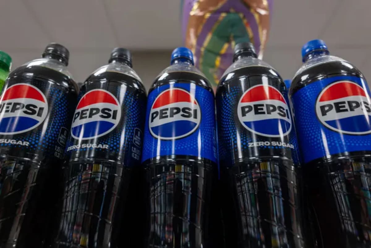 Bottles of Pepsi soda displayed on store shelves showing plastic reduction progress