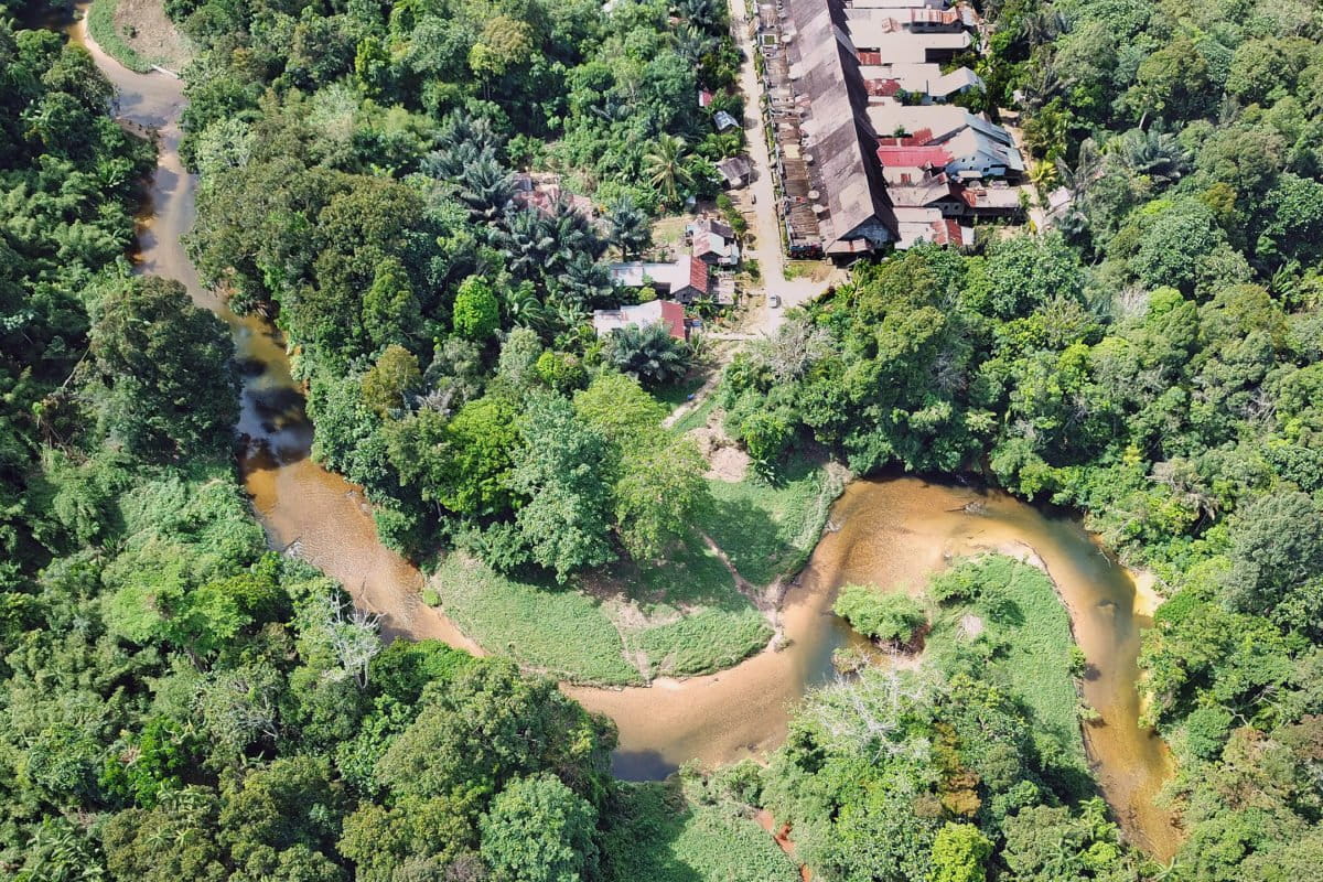 Aerial view of protected rainforest and village homes in West Kalimantan, Indonesian Borneo