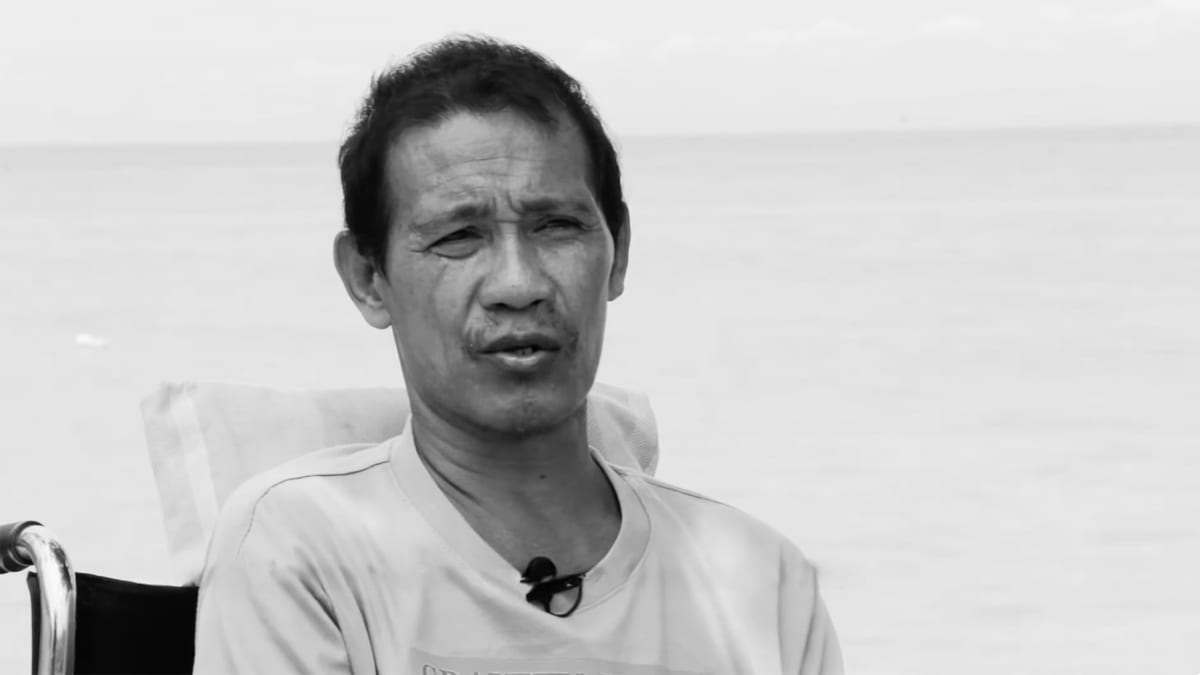 Filipino fisherman Norlan Pagal in wheelchair looking out over coastal waters he protected