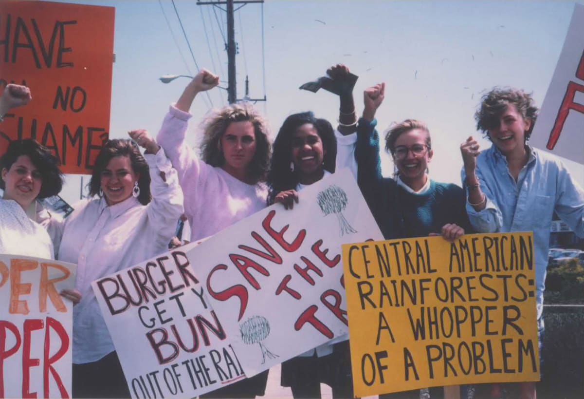 Rainforest Action Network activists protesting outside Burger King restaurant with signs about rainforest protection