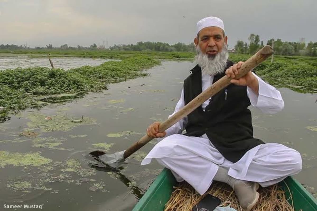 Volunteers cleaning and restoring a wetland lake in Kashmir valley surrounded by mountains