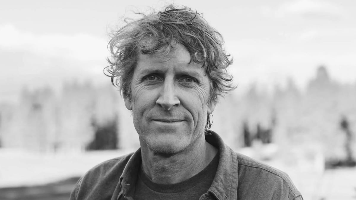 David Page standing outdoors in mountain landscape with winter gear and backpack