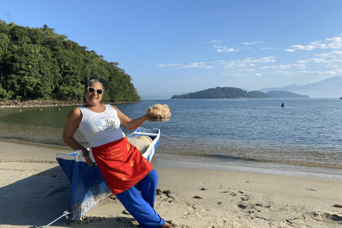 Aparecida Ayres holding fresh seaweed at her beachside restaurant in Paraty, Brazil
