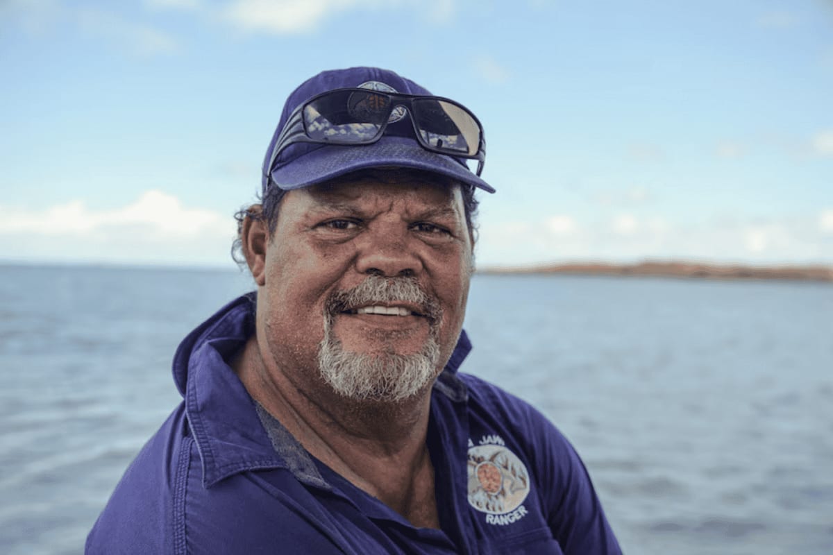 Bardi Jawi ranger Phillip McCarthy standing near mangroves and blue ocean in Kimberley Australia