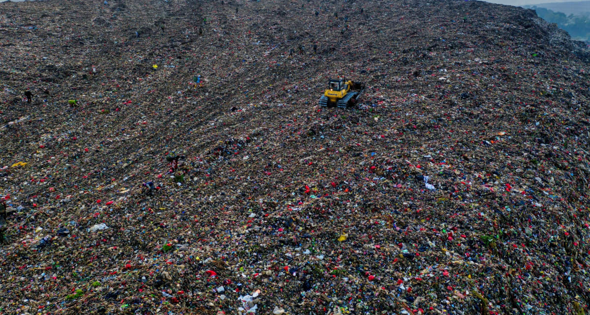 ** Sorted plastic materials ready for recycling in processing facility with international shipping containers
