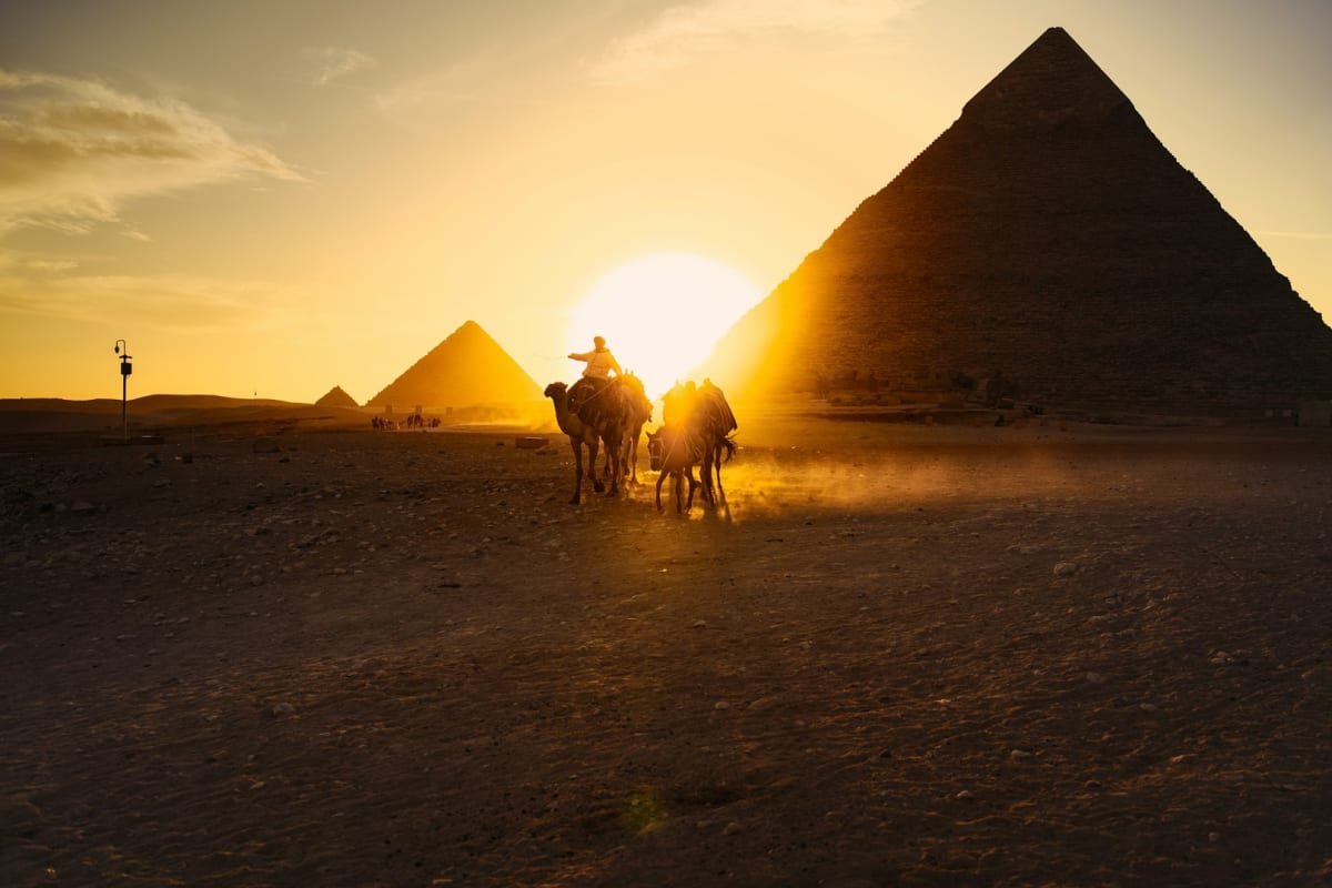 Solar panels and wind turbines against Egyptian desert landscape with modern power transmission lines