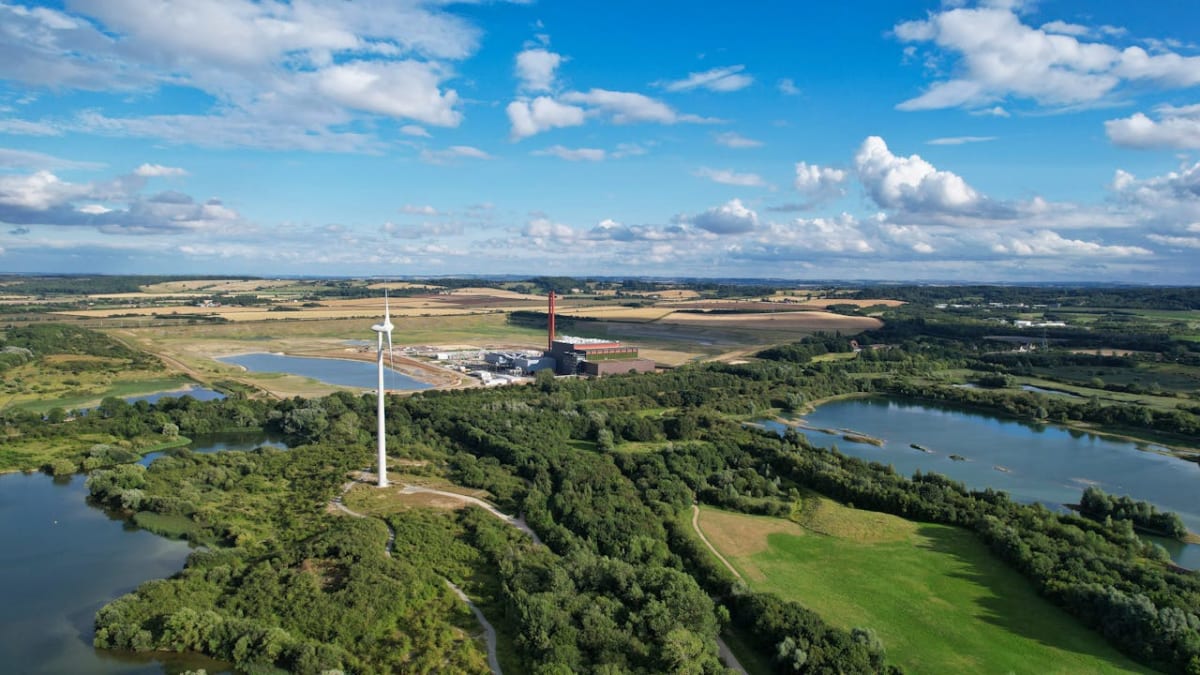Wind turbines and solar panels generating clean renewable energy across British countryside landscape
