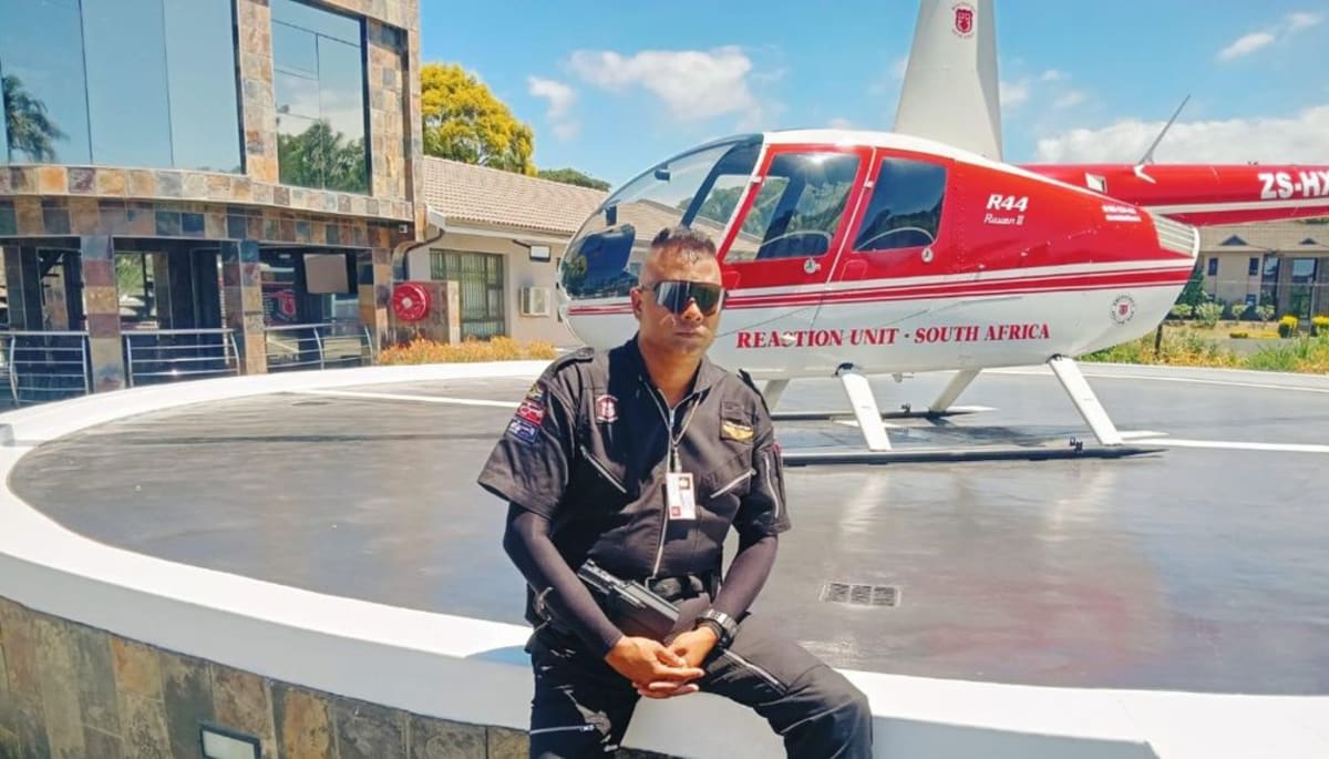 ** Prem Balram, founder of Reaction Unit South Africa, standing in uniform beside emergency response vehicle