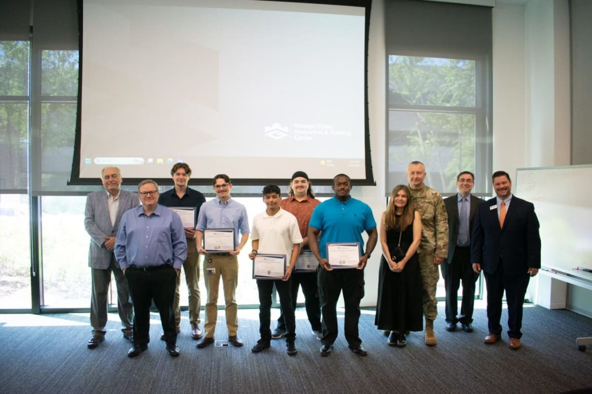 Student holding certificate at Lillian P. and Victor Rattner Scholarship ceremony at Georgia Cyber Center